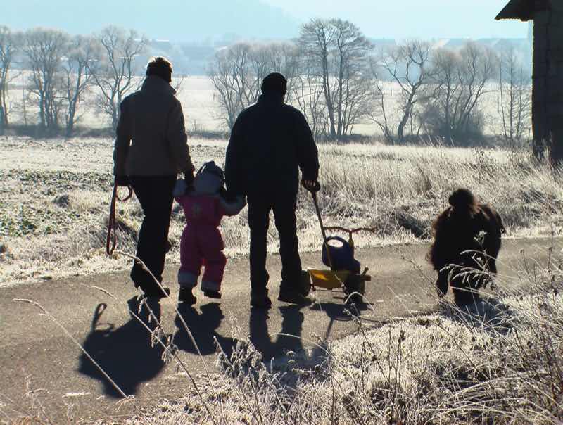 Winterspaziergang mit Familie und Hund